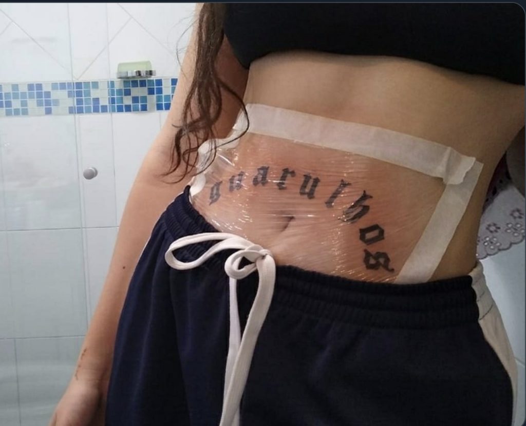 Jovem exibe barriga com tatuagem de Guarulhos
