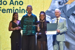 Rebeca Andrade recebendo o prêmio de Ana Moser, ministra do Esporte, e Paulo Wanderley, Presidente do COB