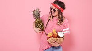 Mulher segura frutas para curtir o Carnaval
