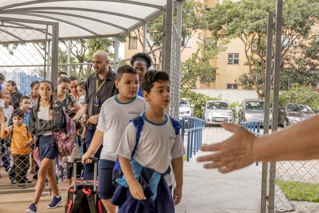 volta às aulas na rede municipal x alunos entrando em escola
