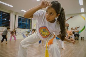 crianças fazem aula de capoeira
