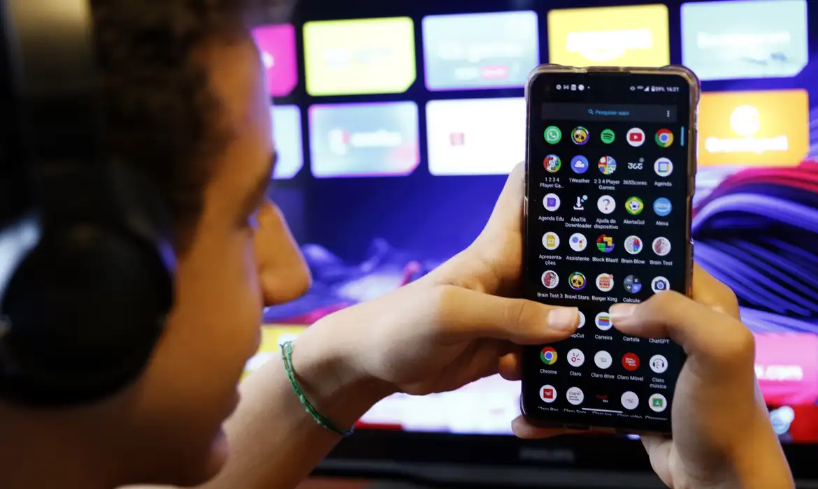 Adolescente usando redes sociais no celular