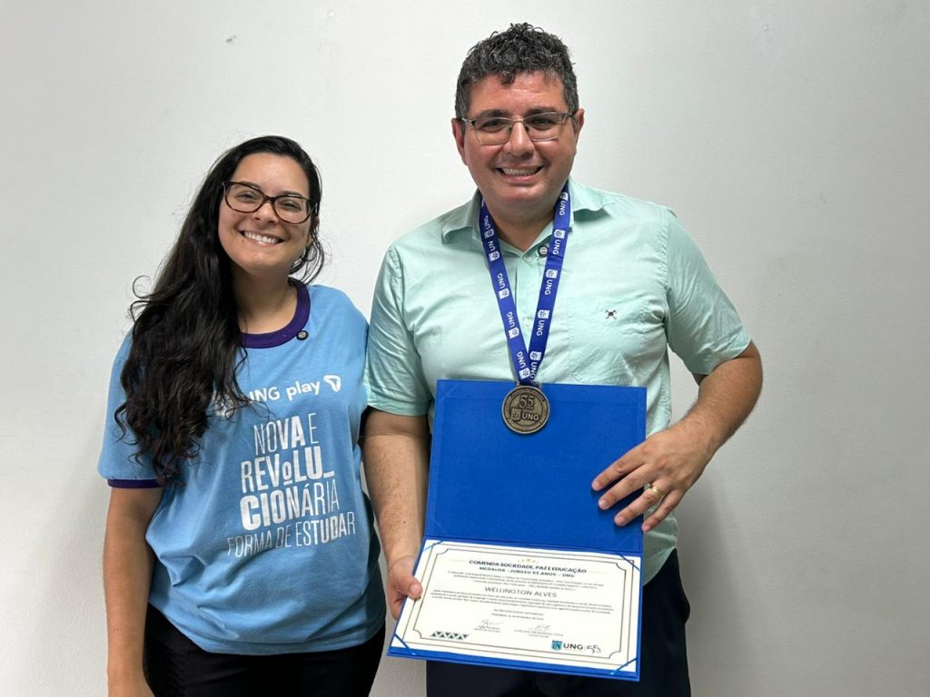 Aline Pinho, da UNG, e Wellington Alves, do GRU Diário, em entrega de comenda